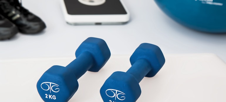 Two blue dumbells on a white floor