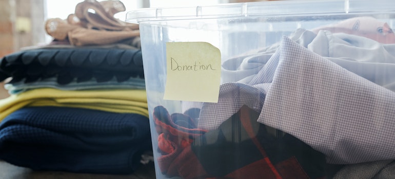 A plastic box is filled with clothes and labeled.