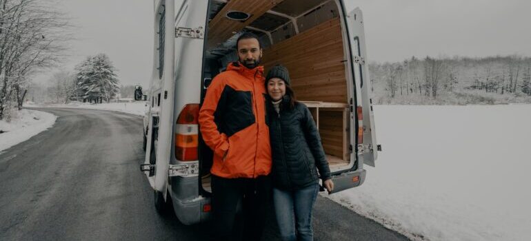 Couple in front of the moving van in the winter