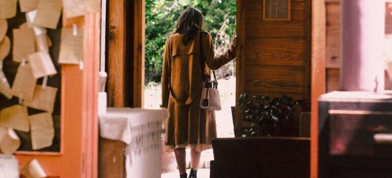 Woman in the brown coat at the door leaving and Moving Out After a Long Relationship 