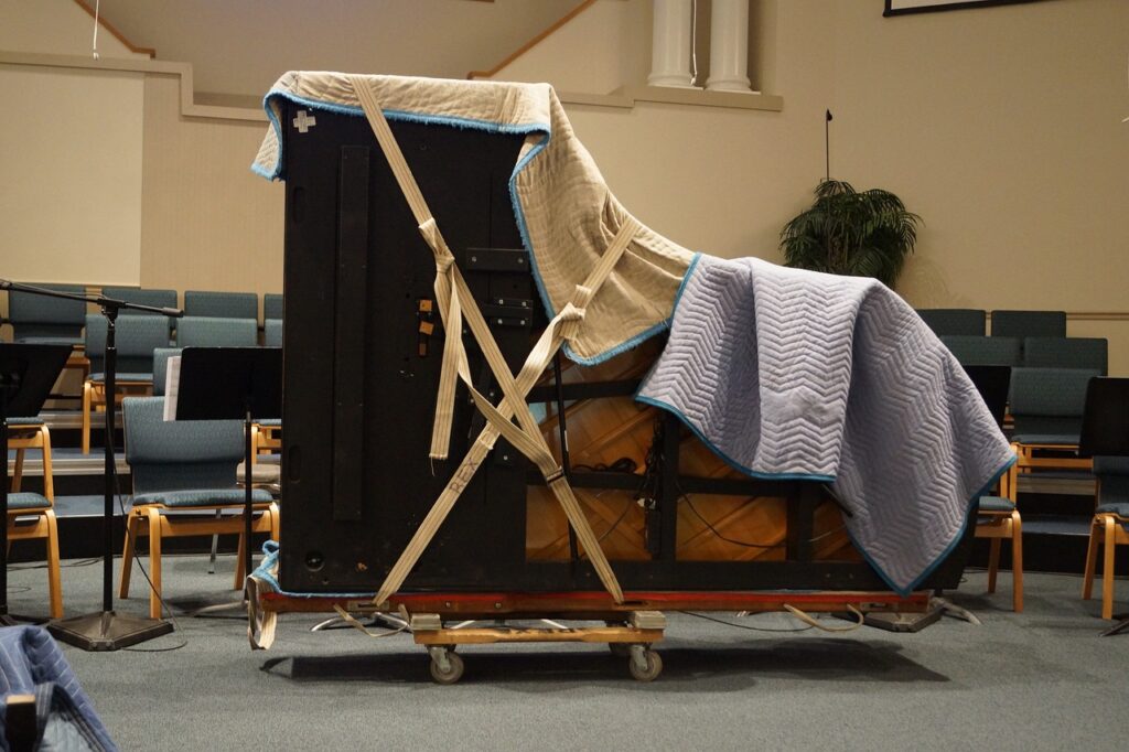 Piano covered in moving blankets ready for winter move in Alexandria