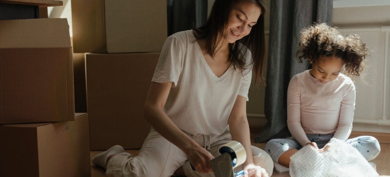 a woman and her child packing because they are moving from Virginia to Maryland