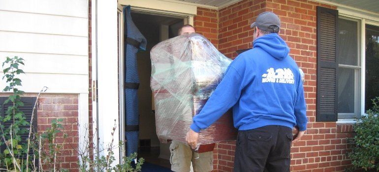 Movers taking a chair out of an apartment.