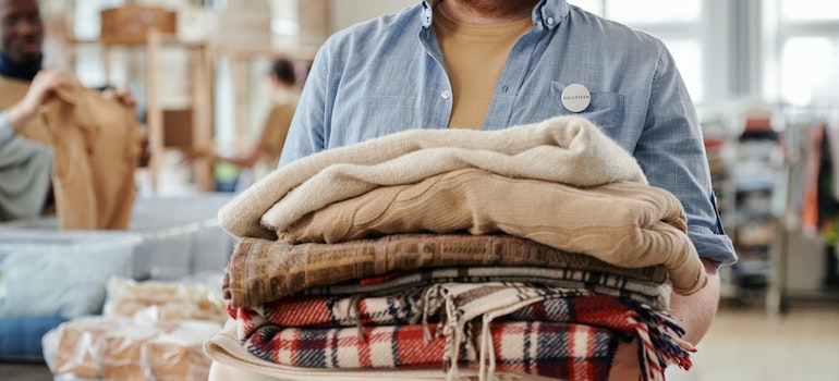 A man holding a pile of blankets