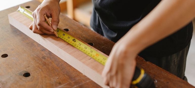 Person measuring a piece of furniture.
