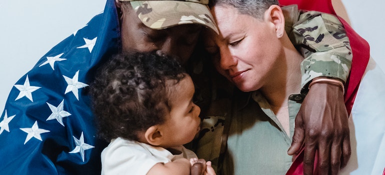 military family hugging wrapped in a flag