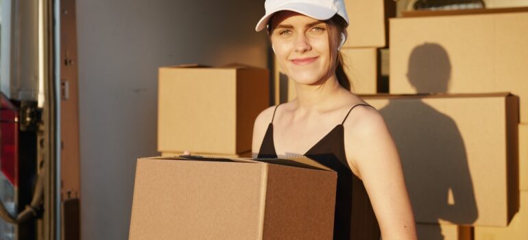 A girl with boxes in her hands thinking - How Much Should I Tip DC Movers?