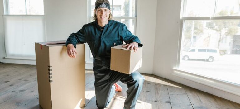 A mover with boxes posing for a photo