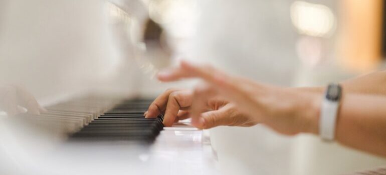 A person playing the piano after they helped prepare your piano for relocation