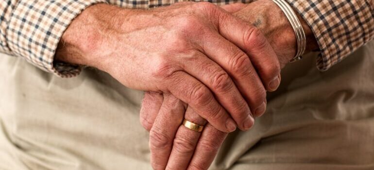 An elderly person crossing hands while thinking about booking a senior move management service