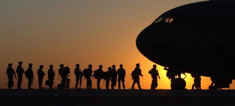 Military personnel getting into the plane