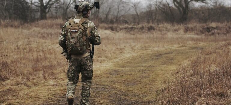 A military person walking through the woods