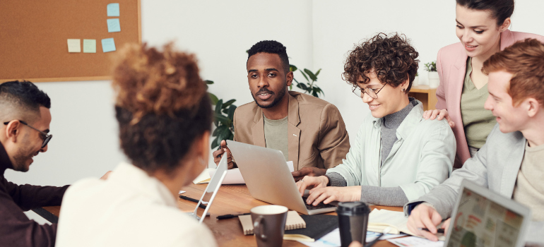 A group of employees exchanging opinions in a meeting which is one of the ways for evaluating the success of your commercial relocation.