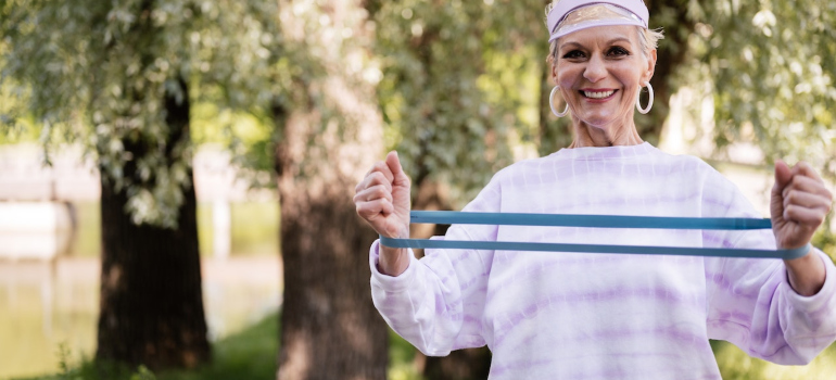 An elderly woman working out in the park.