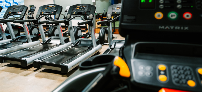 Part of a modern gym with many treadmills.