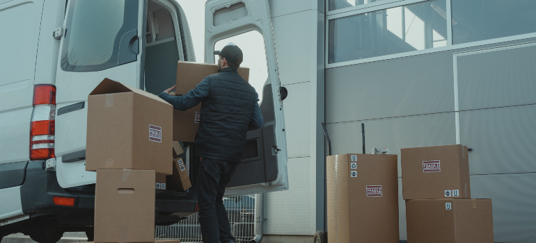 a professional mover loading in cardboard boxes