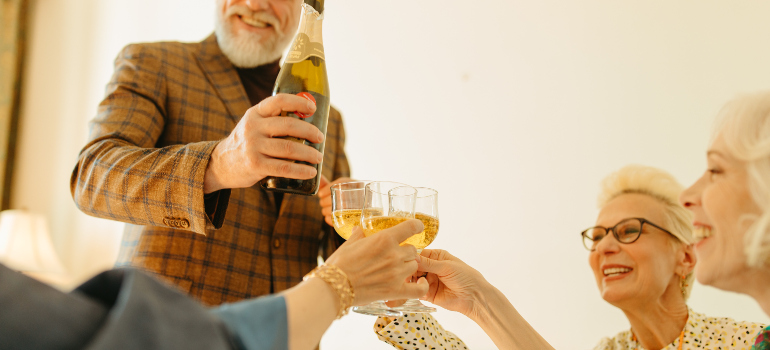 several older citizens drinking champaign and smiling