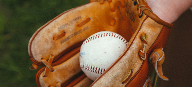 a person holding a baseball in a baseball glove