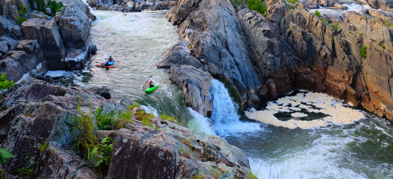 a group of kayakers at a waterfall