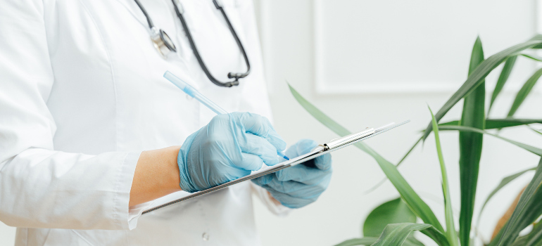 a nurse writing something on a clipboard