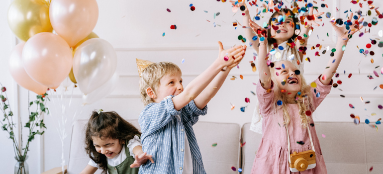 four children enjoying the welcoming party their parents let them plan, which is a great way to involve your children into packing and moving process