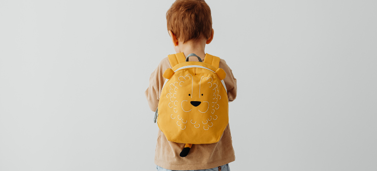a little boy with a lion backpack