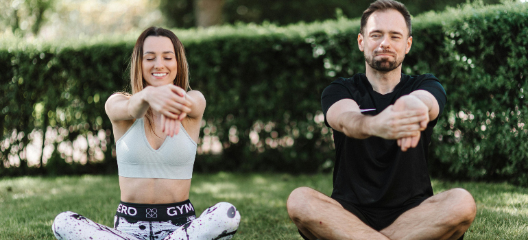 two people stretching in the park