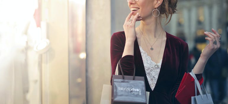 a woman that looks very happy while carrying shopping bags