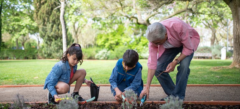 a man and two children planting something in the park
