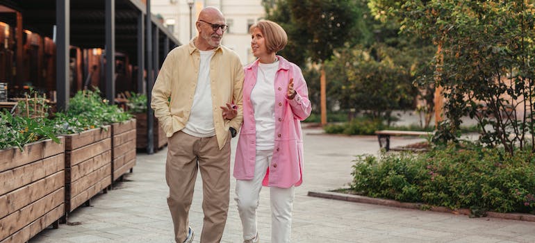 an elderly couple walking through a city center