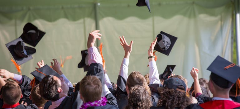 a group of people throwing their graduation hats in the air