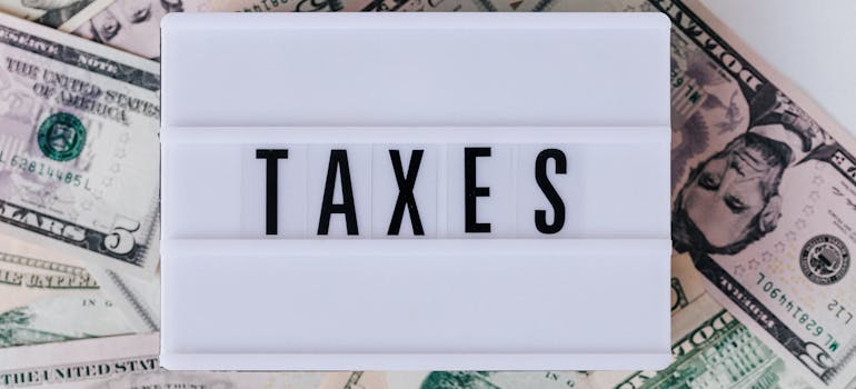 the word "taxes" on a board on top of dollar bills