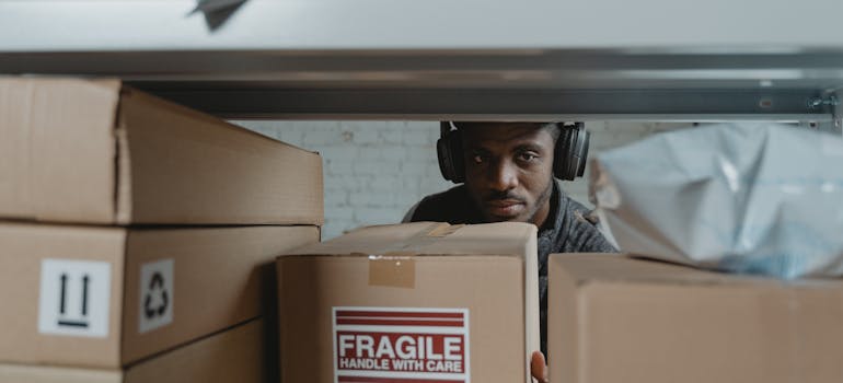 a man wearing headphones while standing behind some boxes