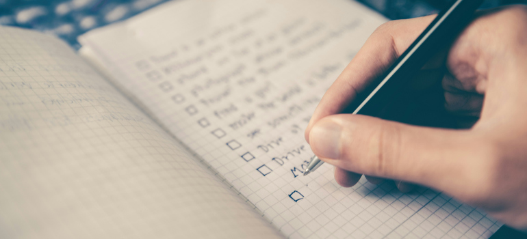 a person compiling a checklist to help them prepare for a long-distance move
