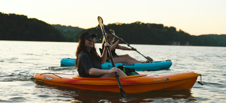 two women smiling while kayaking