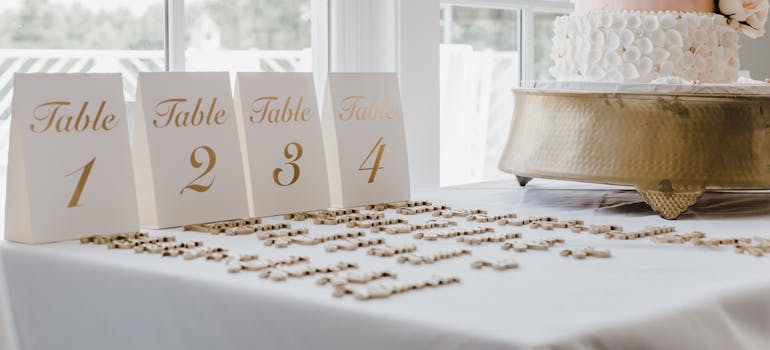 a table with a wedding cake on it and some table numbers