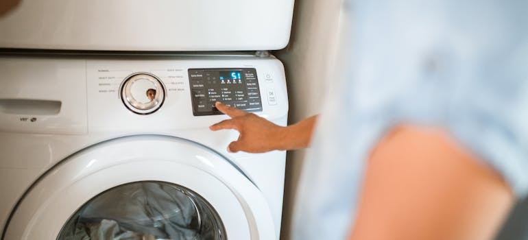 a person switching on a laundry machine