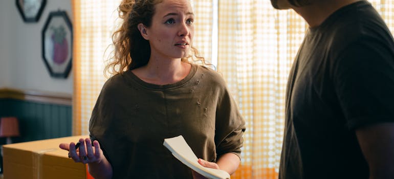 two people discussing something in their living room where a cardboard box is too