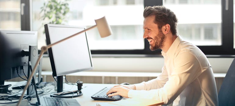 a man reading his e-mail with a very happy expression