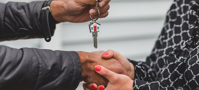 a man handing the house keys to a woman