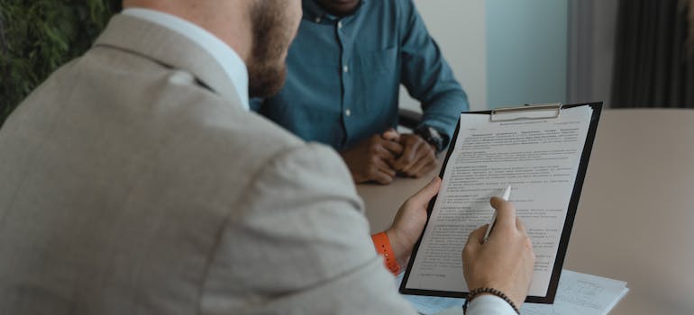 a man helping his friend understand the rental agreement