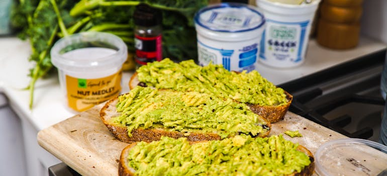 three pieces of whole-grain bread with avocado spread on them