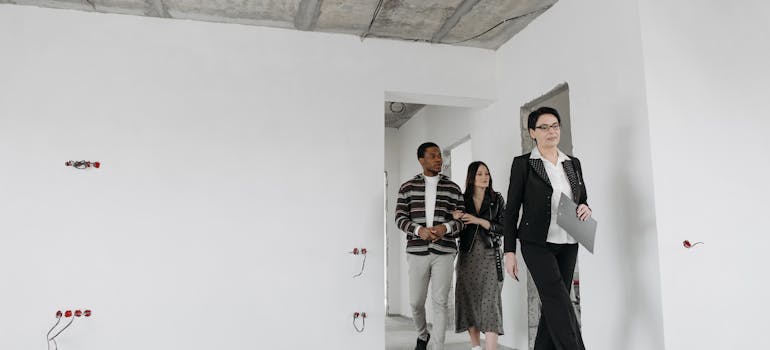 a realtor leading a couple into an empty property