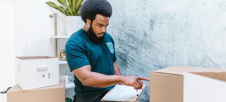 A man working for movers Bowie MD is checking boxes.