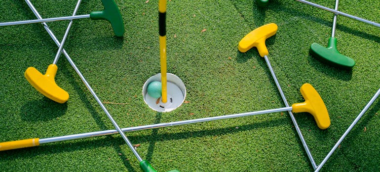 several mini golf clubs arranged around the hole