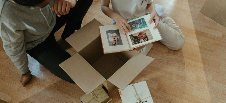 couple looking at a photo album while packing for a move with movers in manassas