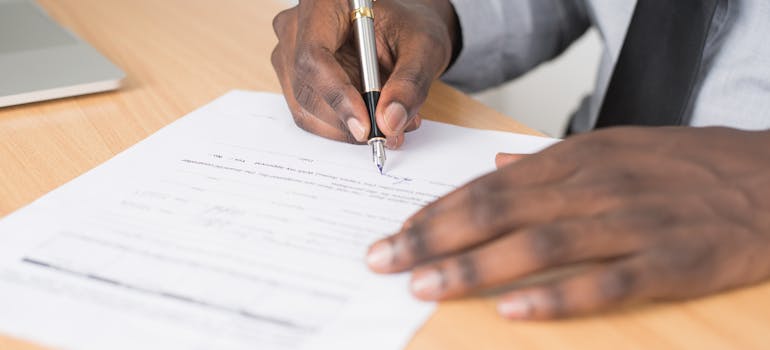 a man filling out a form and signing it