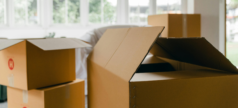 cardboard boxes next to furniture wrapped in plastic