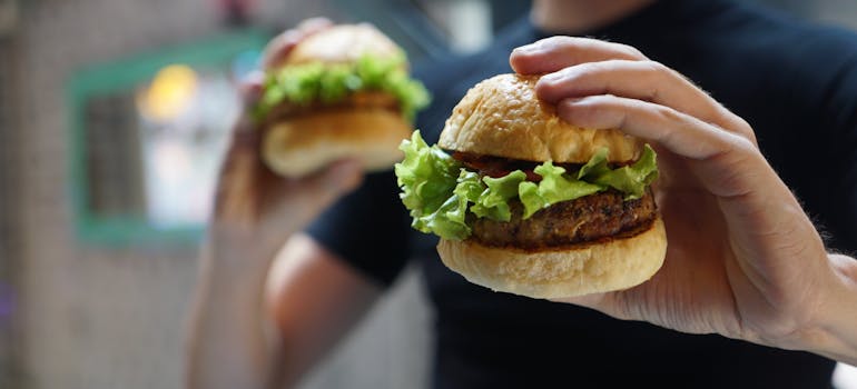 a man holding two hamburgers