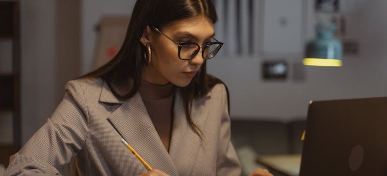 a serious-looking woman who is working on her laptop